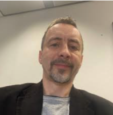 Gerhard in einem Büro mit Jackett.